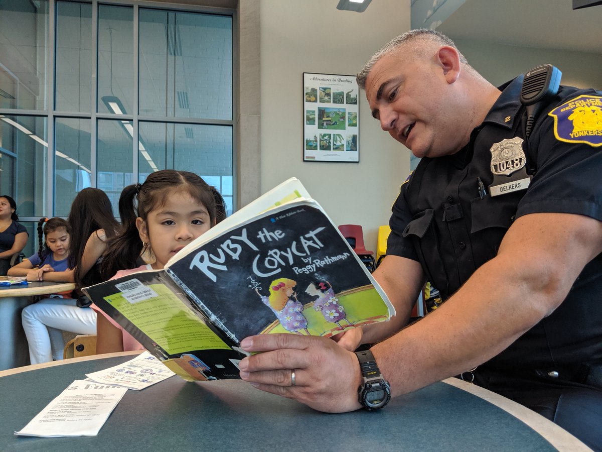 Police officer reads with child.