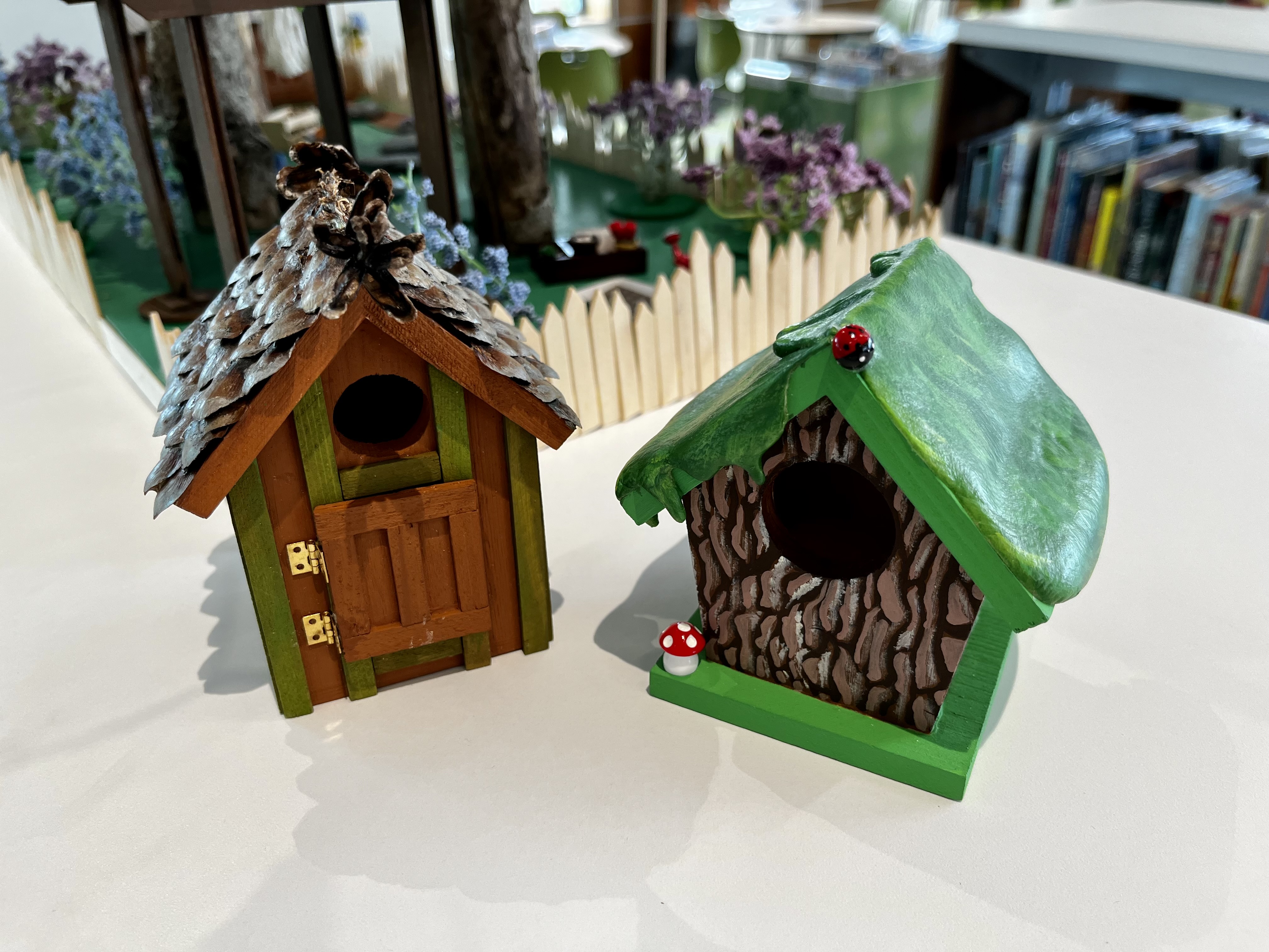 Two small wooden birdhouses painted in various colors