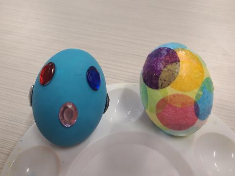 One blue egg with gemstones and another egg covered in multicolored circles