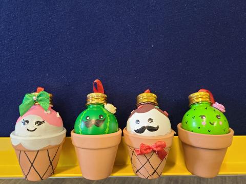 Four little clay pots with ornaments on them, painted to look like ice creams or cactuses.