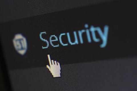 The word security in blue letters on a computer screen with a hand cursor pointing to it