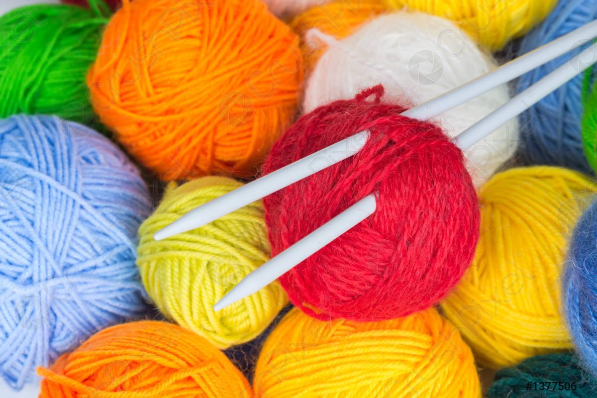 Colorful balls of yarn with knitting needles stuck through one.