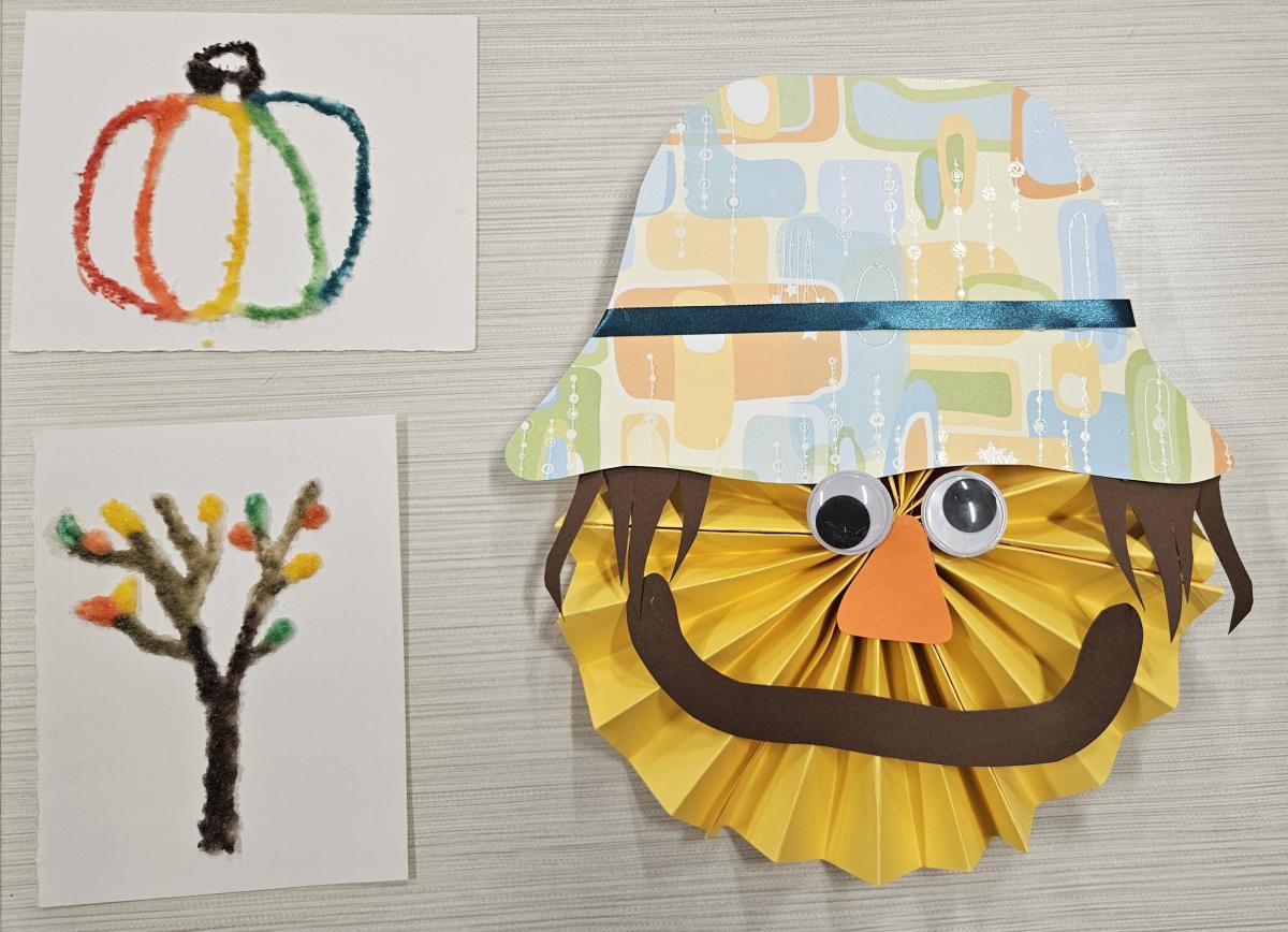 Picture of a paper scarecrow and two small watercolor and salt paintings